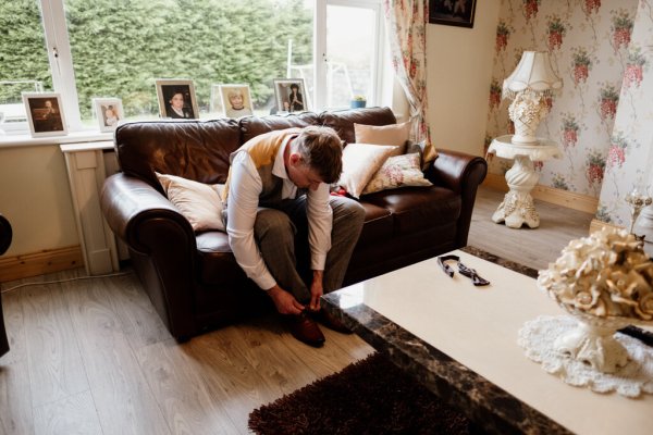 Groom putting shoes on