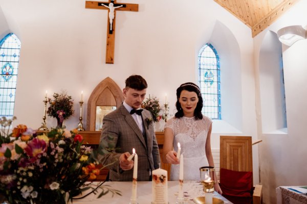 Bride and groom light two candles