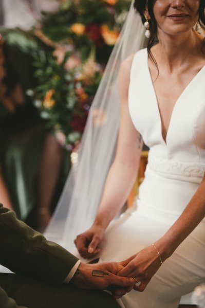 Bride dress derail holding grooms hand