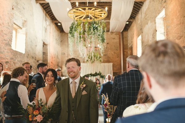 Bride and groom exit ceremonial room with guests