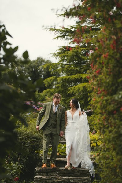 Bride and groom walking down the steps in garden