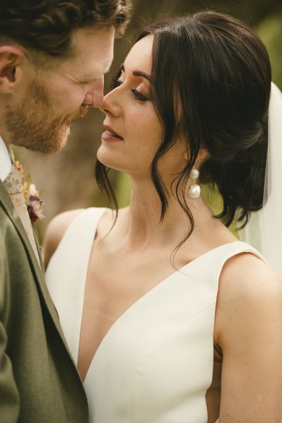 Bride and groom go in for a kiss in garden