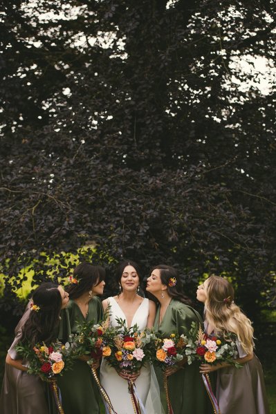 Bride and bridesmaids pose in park