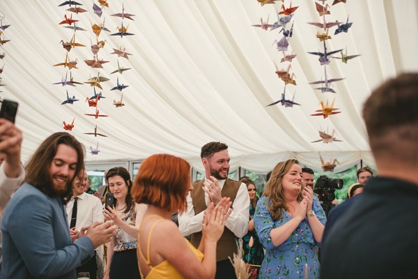 Atmosphere shot of guests clapping for couple