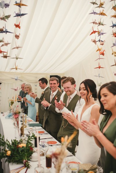 Atmosphere shot of guests clapping for couple bride and groom