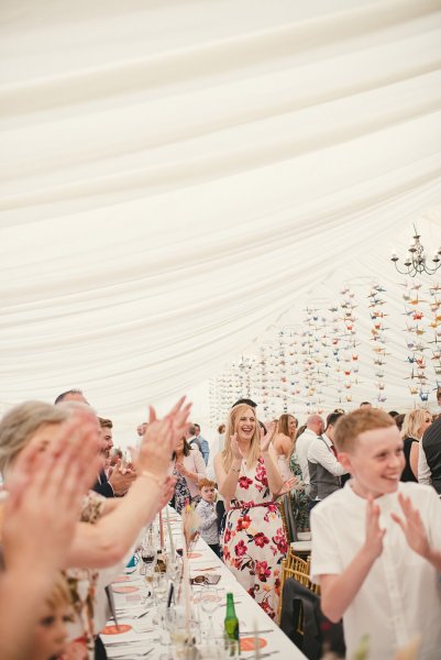 Atmosphere shot of guests clapping for couple