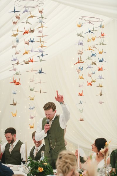 Groom in green suit during his speech