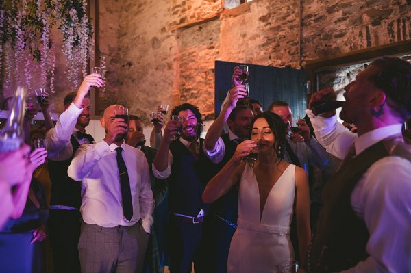 Bride drinks on dancefloor