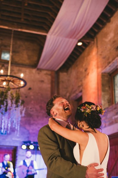 Bride and groom laugh on the dancefloor