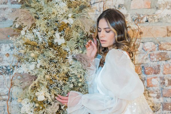 Bride hair detail close up with flowers against wall