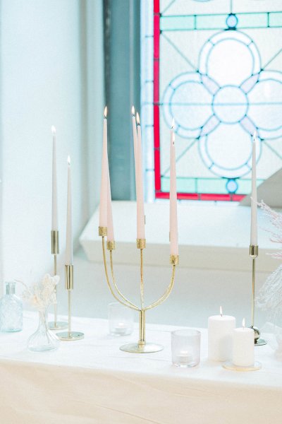 Candles lit on table in front of window flowers setting church tinted