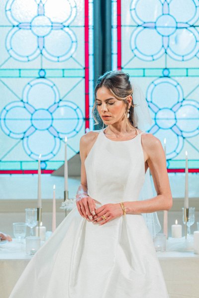 Sleeveless bridal gown/dress bride detail in front of tinted church window