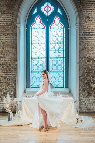 Bride standing at table hand veil detail candle behind hair shot veil