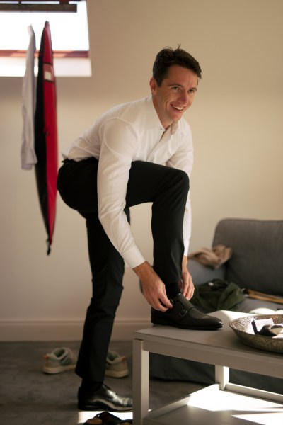 Groom putting on brogues shoes getting ready for wedding