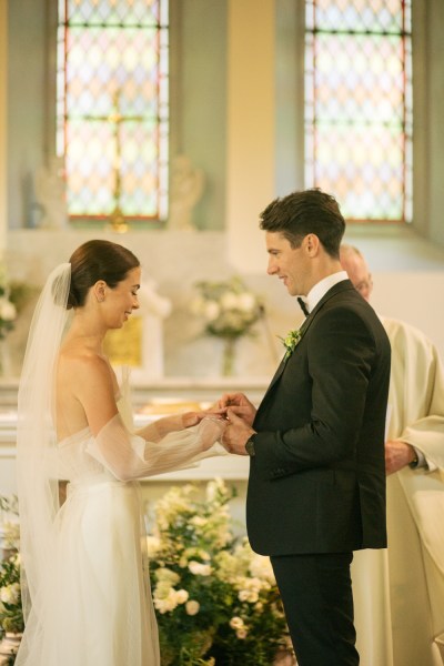 Bride and groom exchange wedding bands rings at the alter