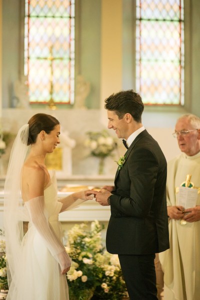 Bride and groom exchange wedding bands rings at the alter