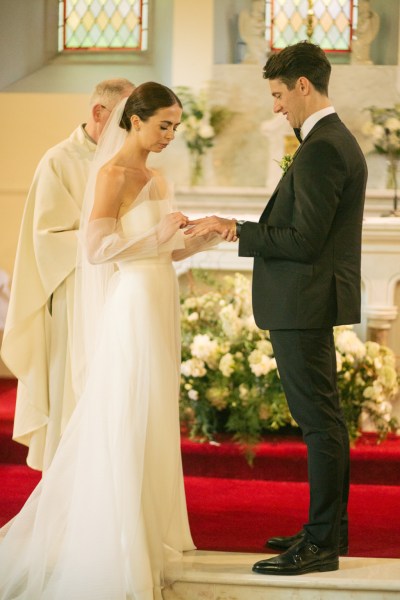 Bride and groom exchange wedding bands rings at the alter