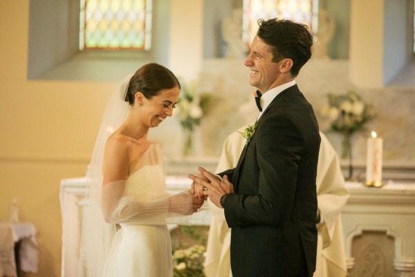 Bride and groom exchange wedding bands rings at the alter