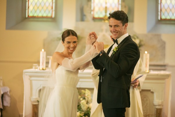 Bride and groom smile at the alter