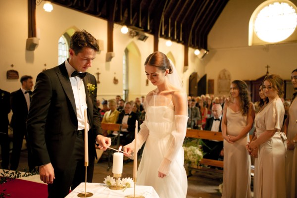 Bride and groom lighting a candle together