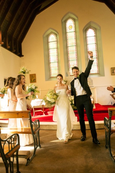 Groom hand in the air guests clapping just wed