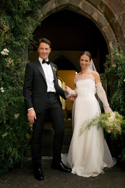 Bride and groom just wed at church entrance smiling