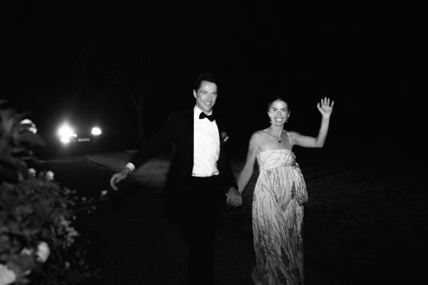 Black and white image of bride and groom hand in hand holding hands