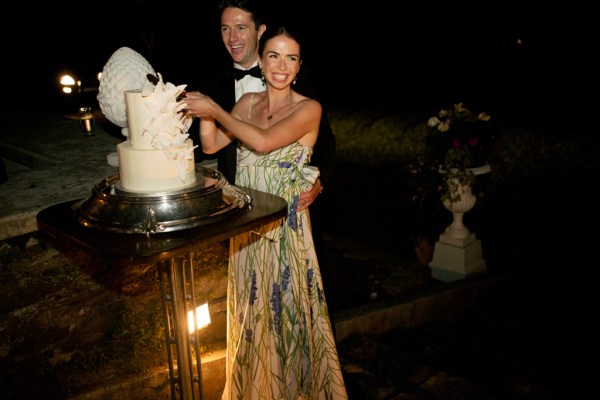 Bride and groom cutting the white wedding cake