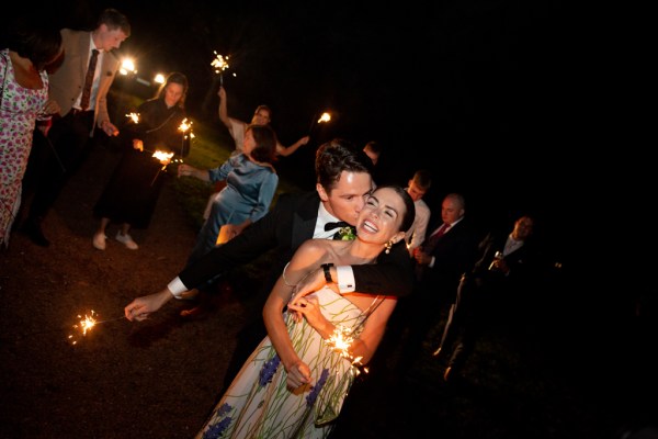 Bride and groom dancing on dancefloor kiss on the cheek