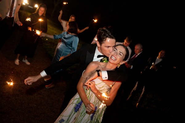 Bride and groom dancing on dancefloor kiss on the cheek