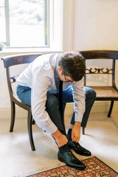 Groom getting ready putting on brogue shoes