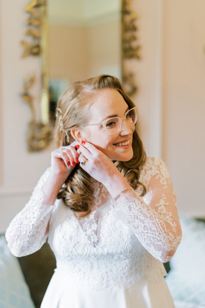 Bride putting on her earrings getting ready