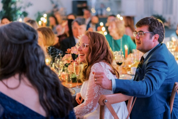 Bride sits at table and laughs