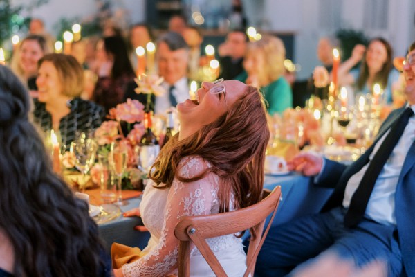 Guests seated laughing audience with bride candles lit