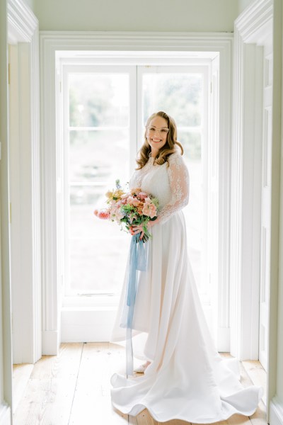 Bride ready for getting holding roses flowers bouquet at window