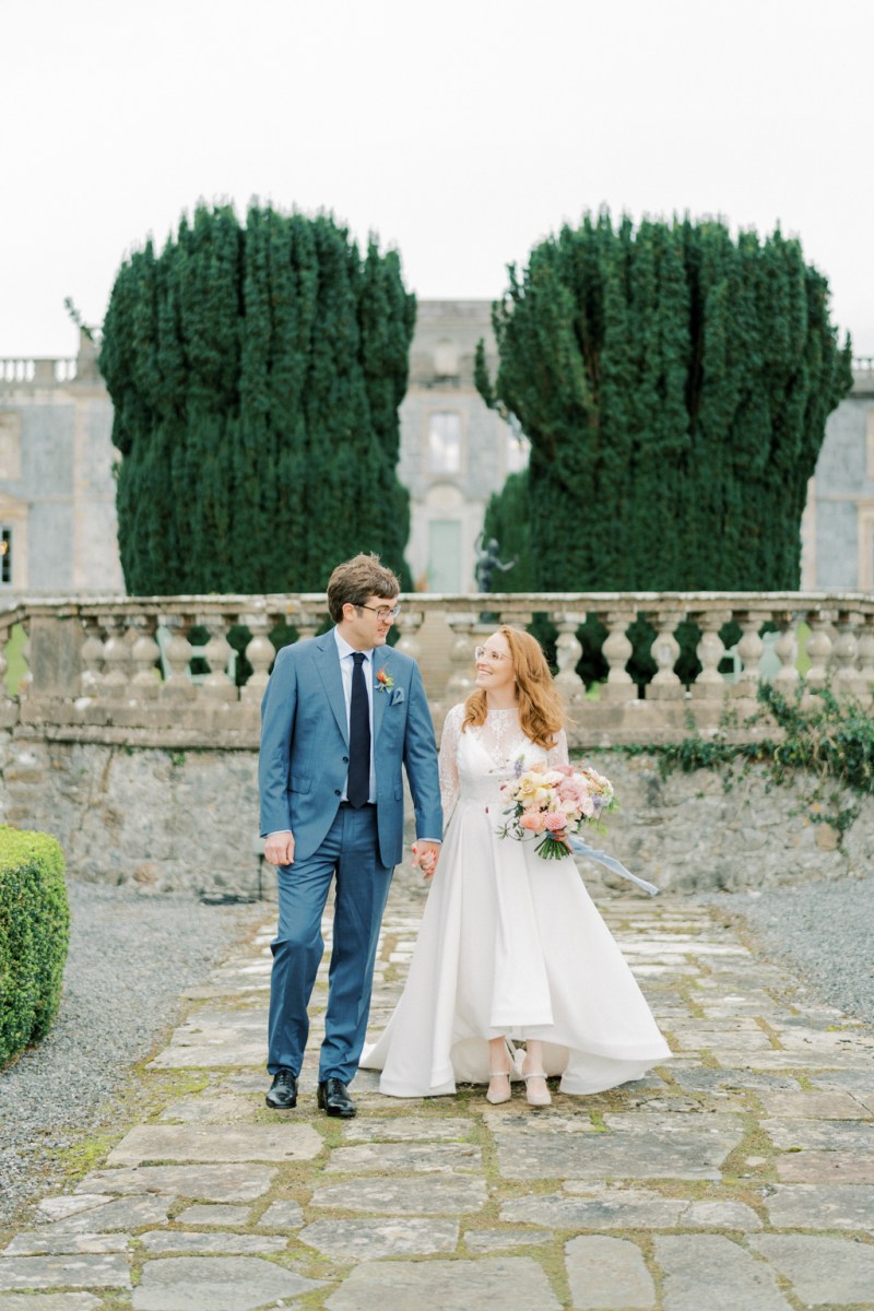 Bride and groom on cobblestone pathway looking at each other