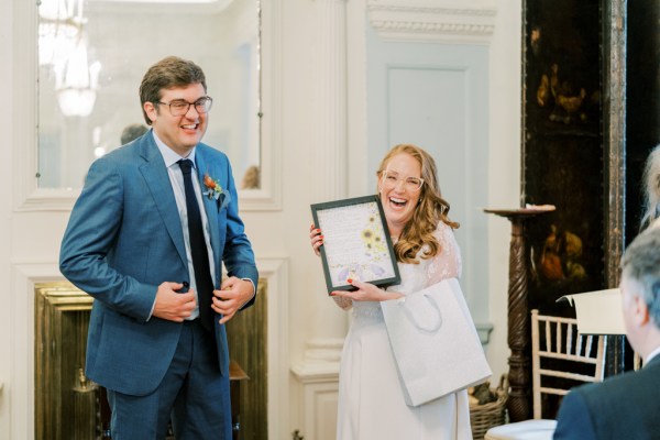 Bride groom hold photo frame laughing