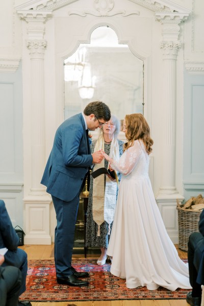 Bride and groom with officiant at alter during ceremony