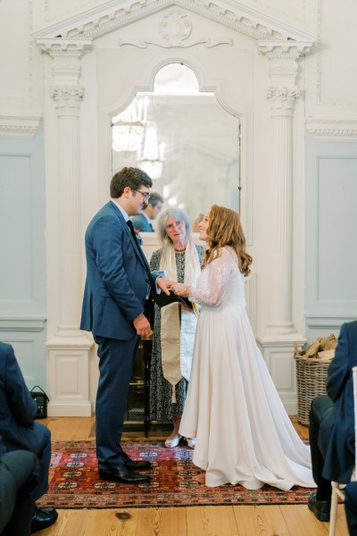 Bride and groom with officiant at alter during ceremony