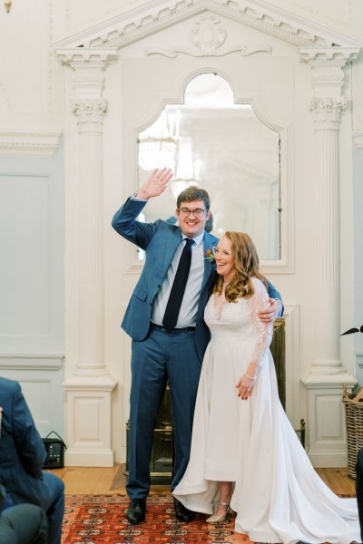 Groom waves happy couple bride setting