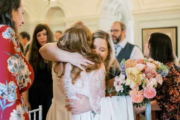 Bride and friend hug embrace