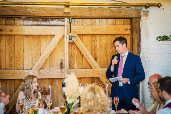 Man gives speech in dining / ballroom setting