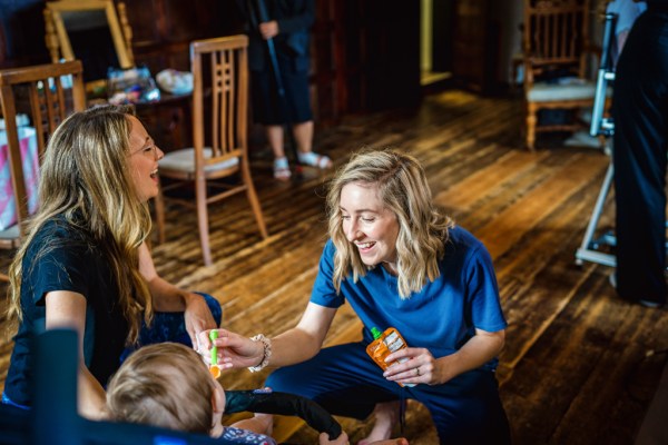 Woman playing with little boy bridesmaids baby