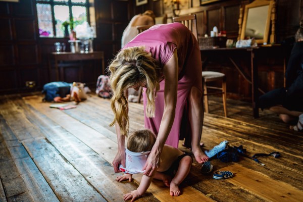 Woman in pink playing with little boy on floor