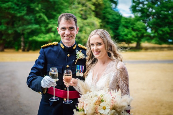 Bride and groom hold champagne holding flowers