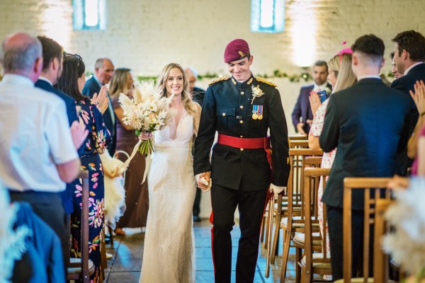 Bride and groom walking down the aisle just wed