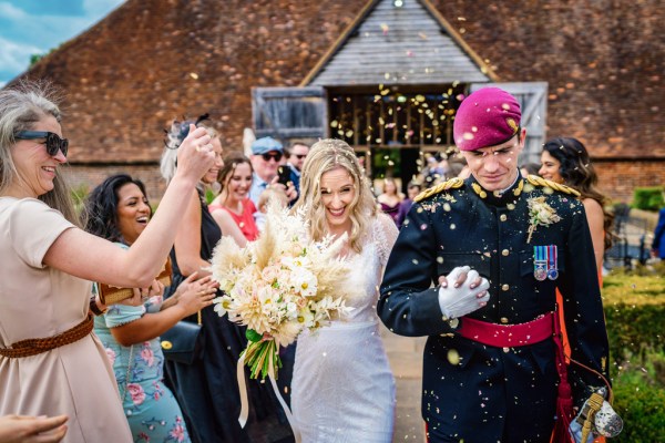 Swords over couples heads bride and groom and guests throwing confetti