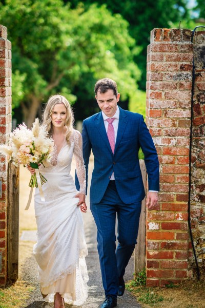 Bride and groom walking together in garden