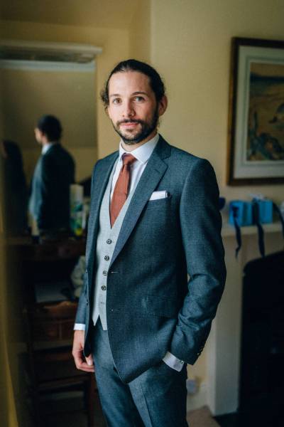 Groom wearing suit poses for the camera