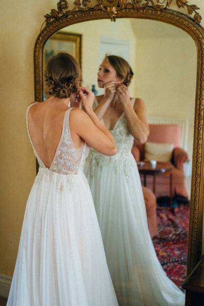 Bride putting on earrings